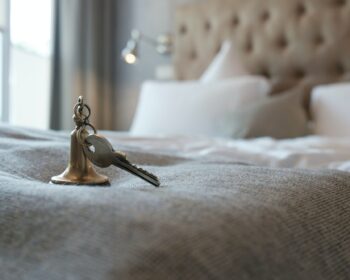 Key with a key fob from the hotel room lies on the bed.